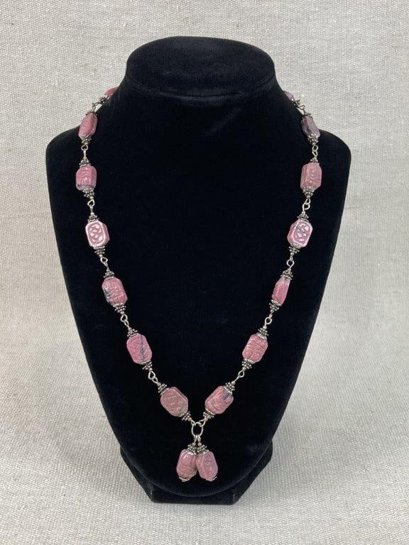 Egyptian Revival Scarab Necklace: This Egyptian Revival scarab necklace features rhodonite gemstone beads showcasing a carved scarab beetle motif. The design is beautifully complemented by textured spacers and finished with