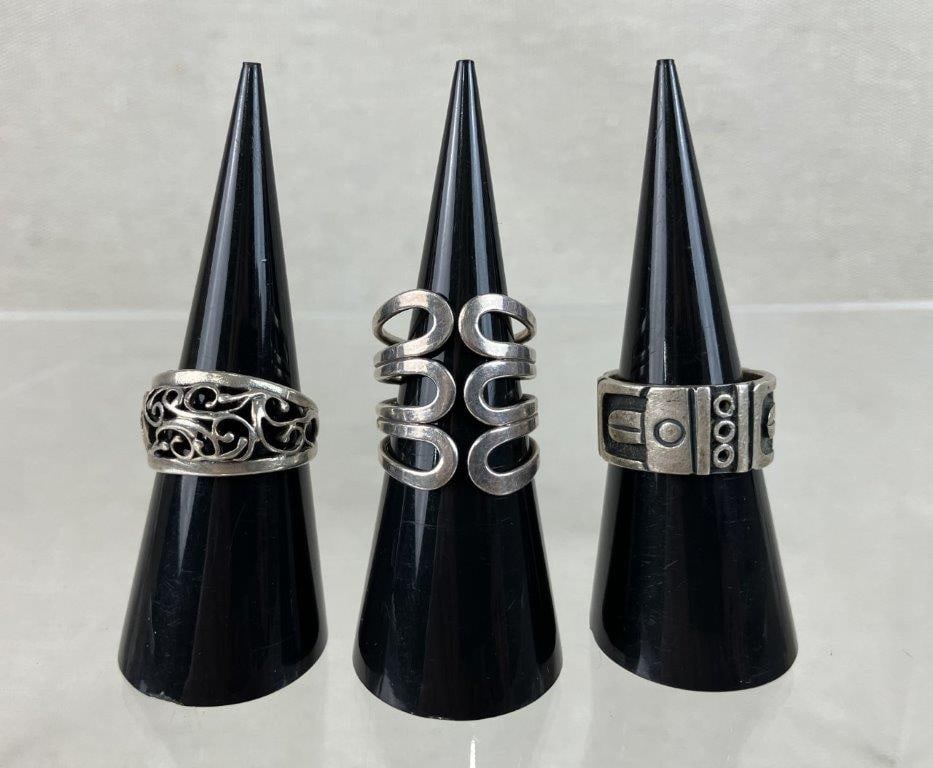 Three Sterling Silver Rings Including Taxco: Three sterling silver rings featuring a standout Taxco ring showcasing a native design across the band with artisan character, marked "Taxco", "Mexico", and "sterling" to the interior of the band. The