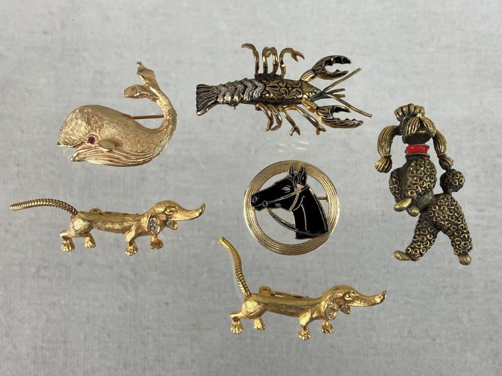 Assortment of Gold-tone Brooches Including Jonette Jewelry and Napier: This six-piece assortment of gold-tone brooches features a variety of whimsical animal designs, including pieces from notable vintage makers. The assortment includes two gold-tone Dachshund brooches f