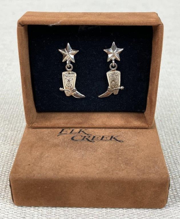 Elk Creek Sterling Silver Cowboy Boot Dangle Earrings: A charming pair of sterling silver dangle earrings by Elk Creek, capturing a quintessential Western aesthetic. Each earring features a faceted star post from which a detailed cowboy boot dangles,