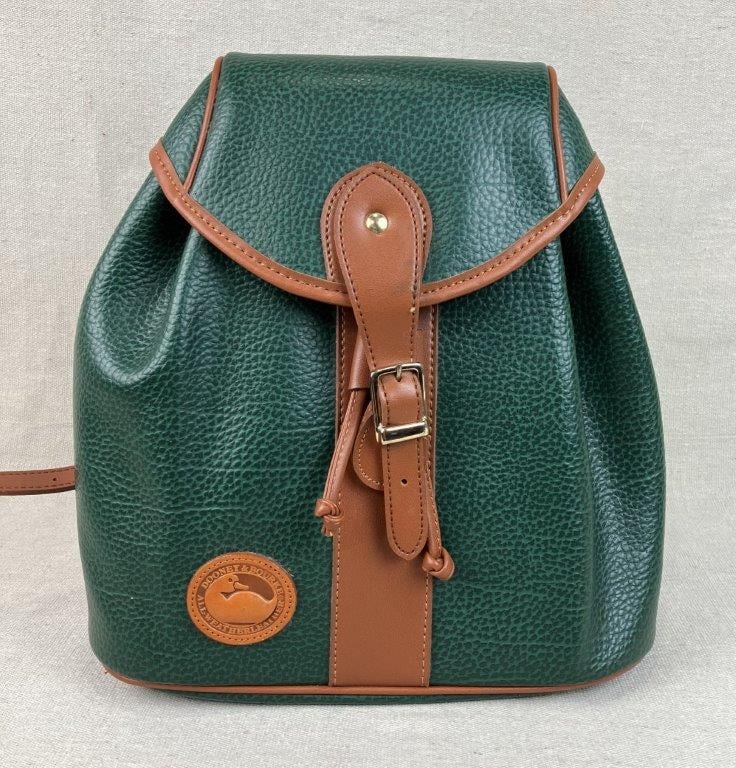 Dooney & Bourke All Weather Leather Backpack: A classic small-profile backpack from Dooney & Bourke, crafted from their signature "All Weather Leather" in a rich, forest green pebbled finish. The design features a secure magnetic closure