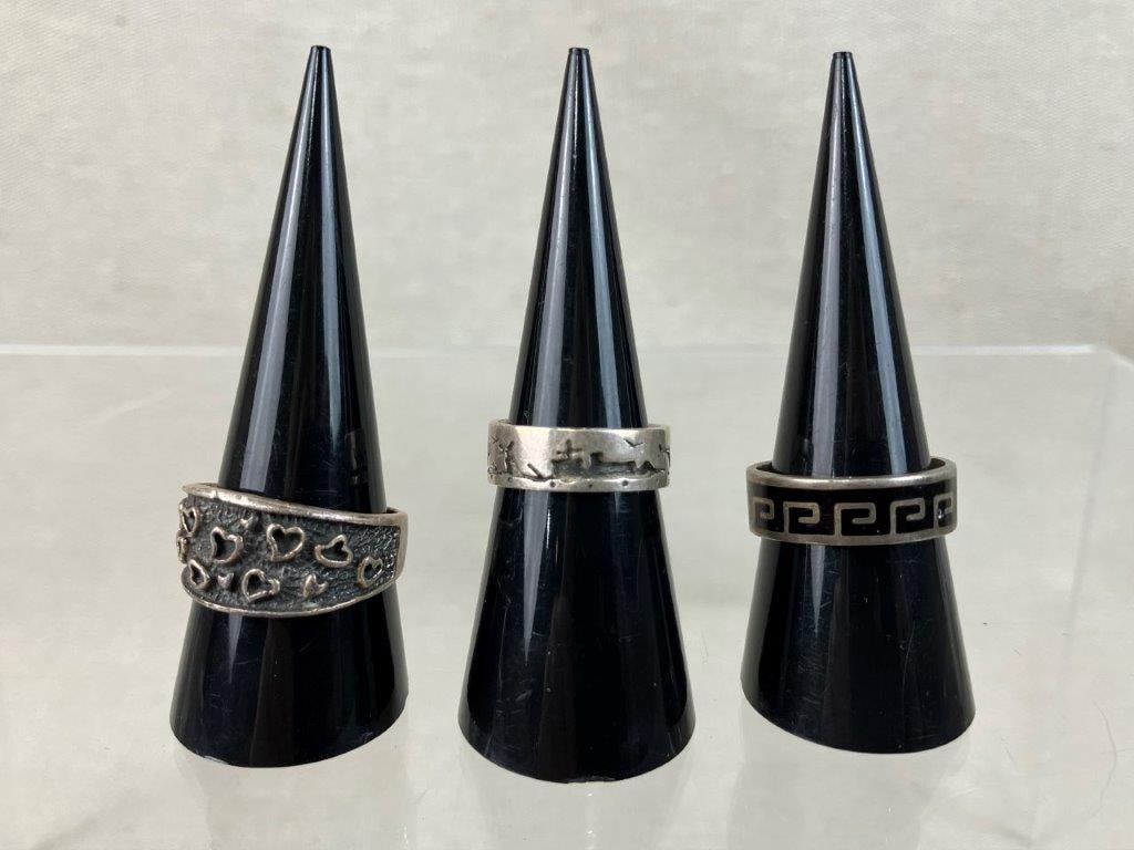 Three Vintage Sterling Silver Rings Including Jerome Begay: This three-piece collection of vintage sterling silver rings showcases a diverse mix of Southwestern artistry, cultural motifs, and bold textures. The assortment includes a handcrafted Navajo