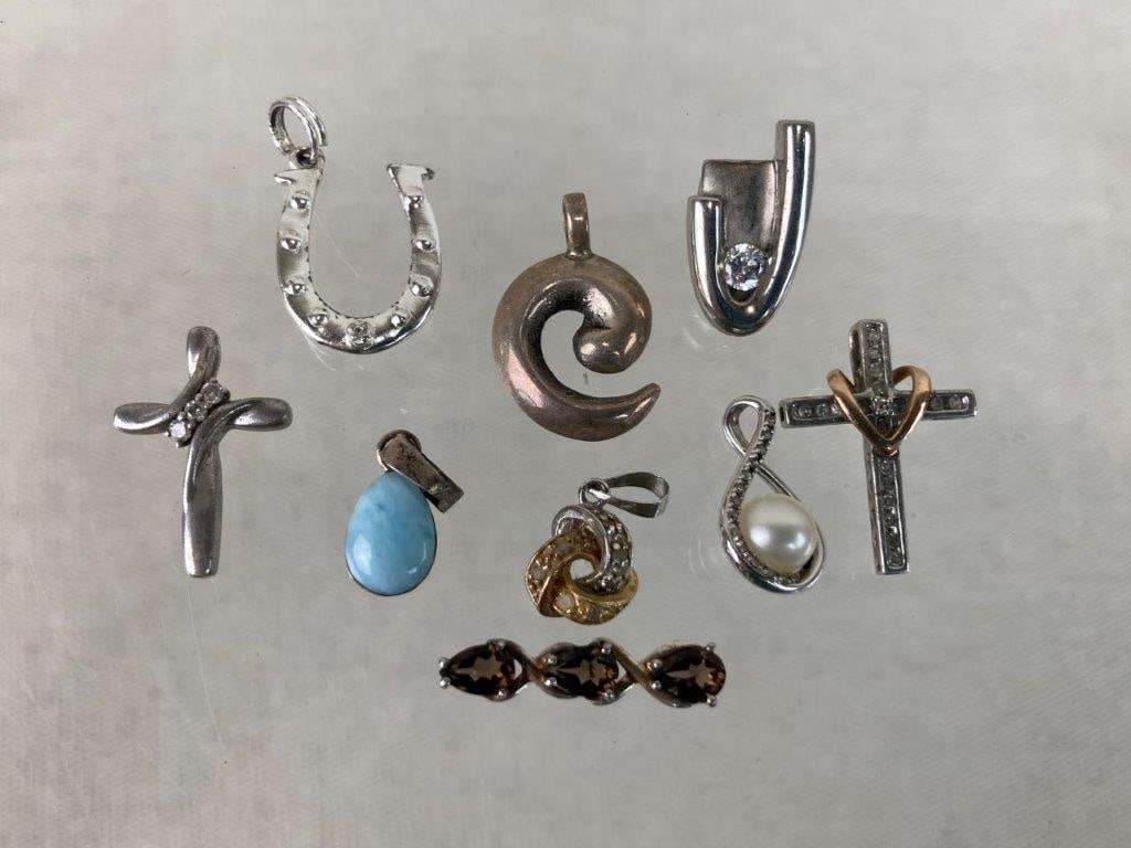 Assortment of Sterling Silver Pendants: This nine-piece assortment of sterling silver pendants features an elegant array of classic, symbolic, and detailed designs. The assortment includes a teardrop-shaped pendant set with a round