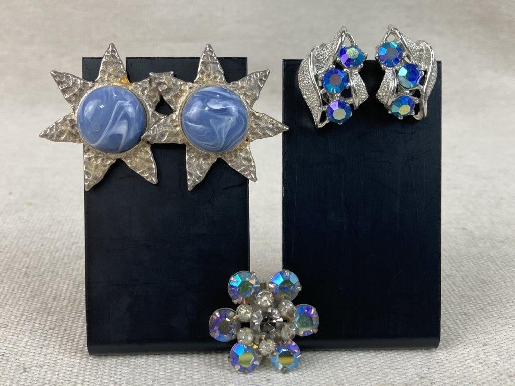 Two Pairs of Silver-tone Earrings with Brooch: This assortment features two pairs of silver-tone earrings and a brooch showcasing vibrant textures and shimmering accents. The assortment includes a pair of earrings with a sunburst design featuring
