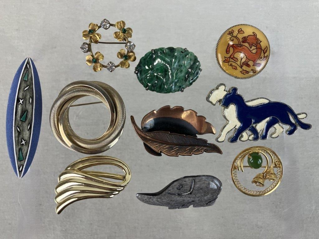Costume Brooch Assortment Including Piscitelli and Coro: This ten-piece assortment of vintage costume brooches features a diverse variety of styles in mixed-tone metals. Highlighting the assortment is a copper-tone feather brooch displaying a textured