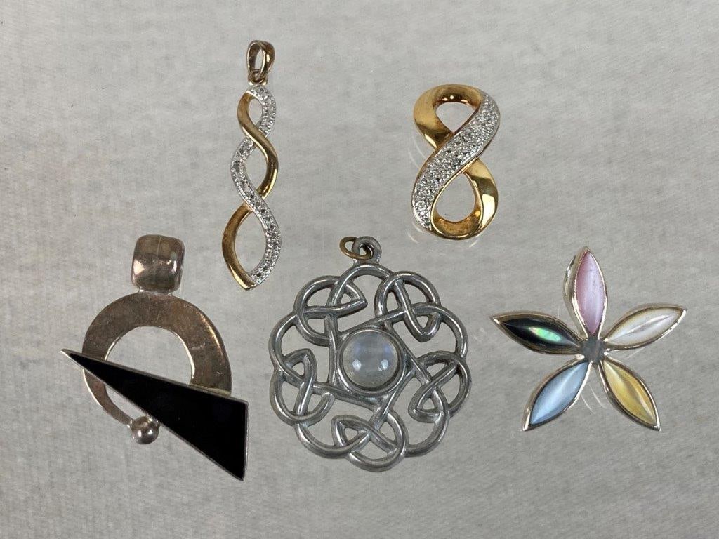 Assortment of Sterling Silver and Costume Pendants: This five-piece assortment of pendants features a lovely mix of sterling silver, modern geometries, and iridescent textures. The assortment highlights an abstract geometric pendant set with a