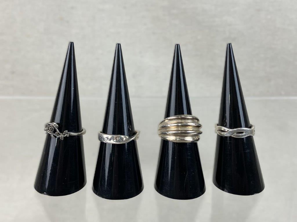 Assortment of Sterling Silver Rings: An assortment of four sterling silver rings featuring a lovely variety of floral accents, structural shapes, and inspirational text. The assortment includes a simple band ring with an ornate rose and