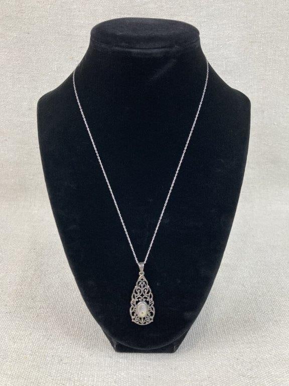 Sterling Silver Art Nouveau Necklace: This sterling silver necklace features a teardrop-shaped pendant displaying an elegant openwork Art Nouveau-style filigree design centered with an iridescent abalone shell. Suspended from a 17 1/2