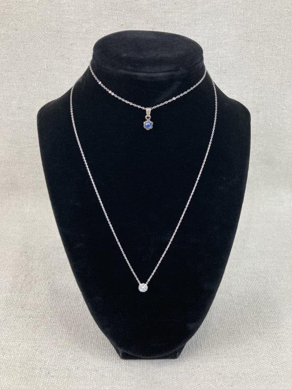 Two Sterling Silver Necklaces: A delicate couple of sterling silver necklaces adorned with a multitude of faceted gemstones, highlighted by one piece showcasing a sterling flower setting centered by a blue tanzanite stone. One