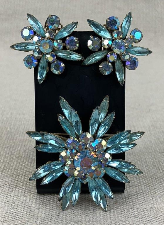 Judy Lee Snowflake Brooch and Earrings: This vintage snowflake-design costume jewelry set by Judy Lee includes a coordinating brooch and clip-on earrings. The pieces feature pointed aqua blue marquise-cut stones radiating outwards,