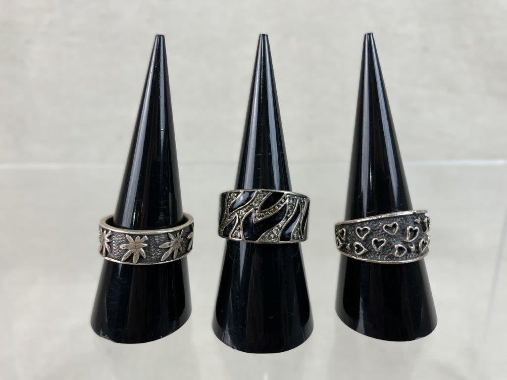 Sterling Silver Fashion Rings: This three-piece assortment of wide-band sterling silver rings showcases bold, expressive designs and rich textures. The assortment includes a striking zebra-stripe ring detailed with black enamel str