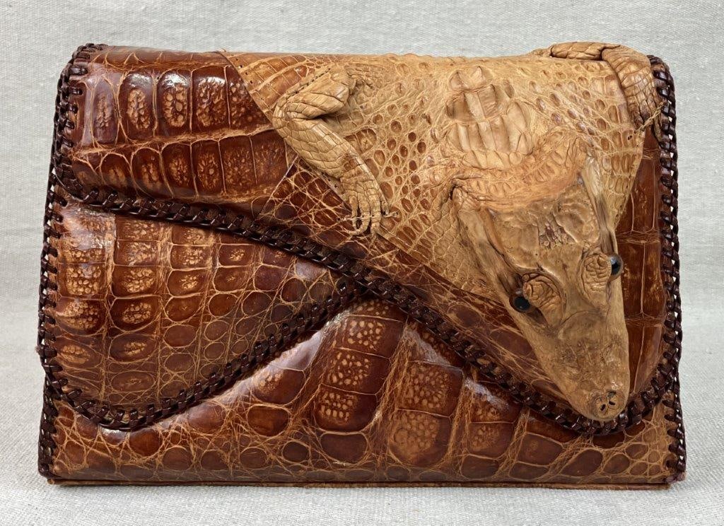 Vintage S & S Alligator Taxidermy Purse: A striking and provocative mid-century accessory, this structured purse is crafted from genuine alligator leather with reinforced stitched edges. The design is highlighted by a taxidermy baby