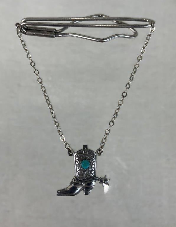 Sterling Silver and Turquoise Cowboy Boot Tie Clip: Sterling silver tie clip featuring a Western style cowboy boot motif, marked for silver content and centered by a turquoise stone, with a decorative chain attachment. Boot element measures approx. 1"