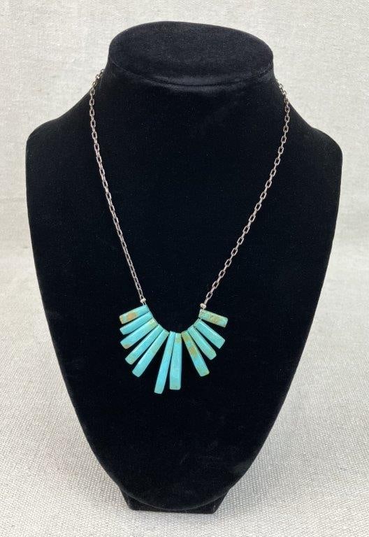 Native Artisan Sterling Silver and Turquoise Fan Necklace: Sterling silver necklace featuring a fan-form pendant composed of cut turquoise stones arranged in a radiating design, suspended from a sterling silver linked chain, clasp marked for silver content.