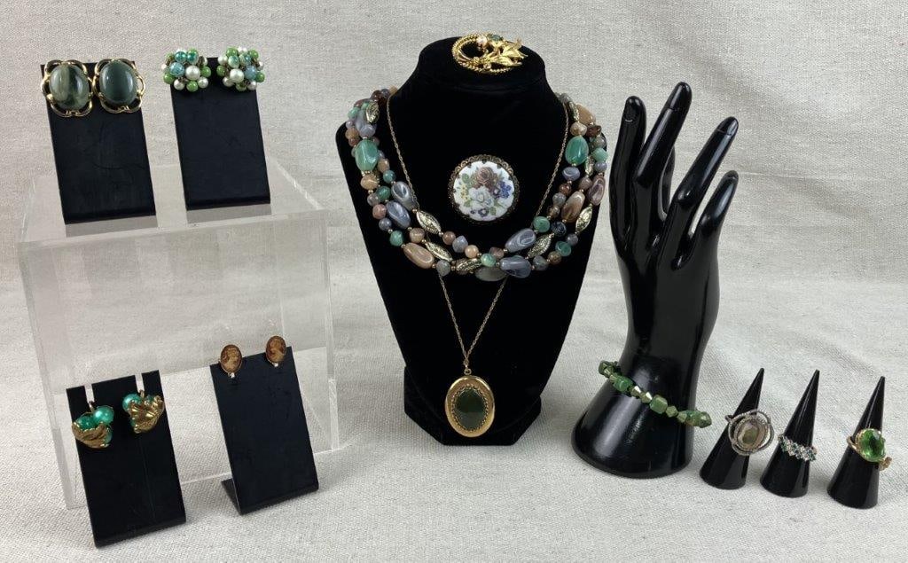 Earth and Gold-tone Jewelry Assortment: This varied jewelry collection features an earthy gold-tone palette, with many pieces highlighting vibrant green stones. This assortment includes a gold-tone locket necklace set with a dark green jade