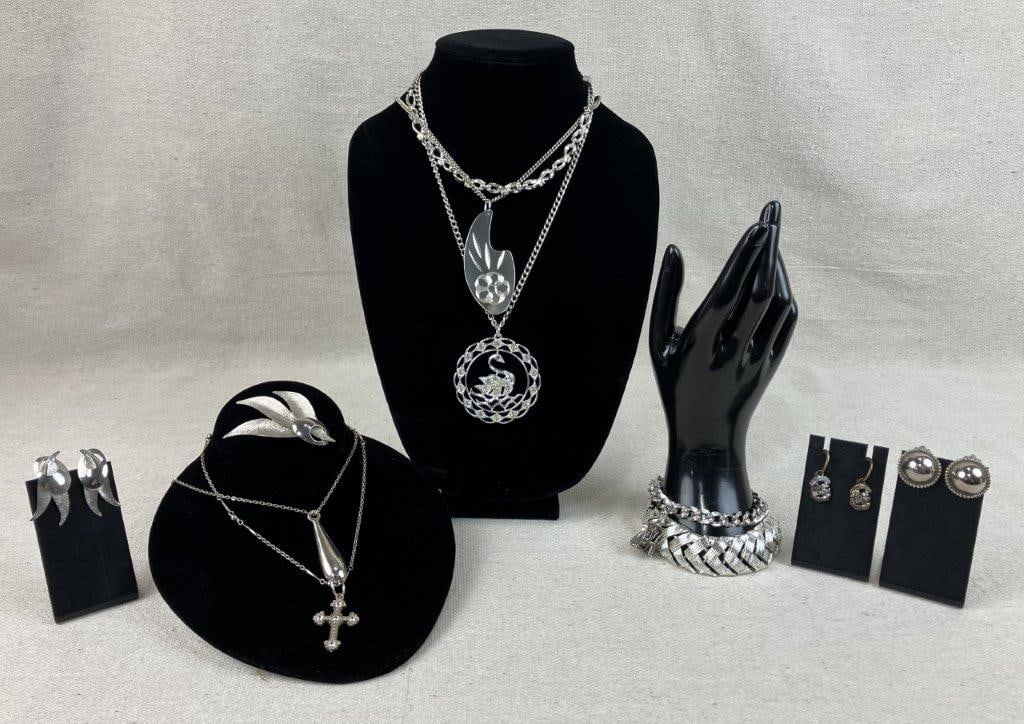 Silvertone Costume Jewelry Assortment: Group of eleven pieces of vintage costume jewelry in silvertone, including a Martha Washington charm bracelet, an articulated bracelet, five necklaces including one with a swan motif, and a