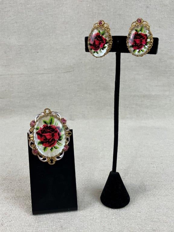 Vintage Rose Painted Brooch and Earrings: This vintage gold-tone jewelry set features a brooch with a reverse painted glass rose centered in a reticulated scrollwork frame set with pink rhinestones. The set includes a matching pair of