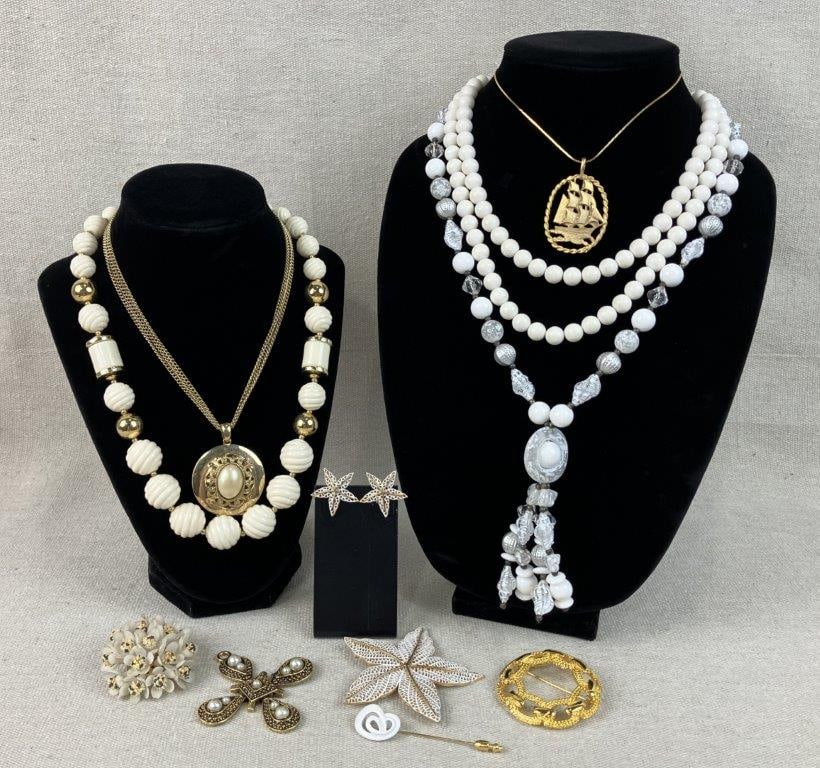 Gold Tone and Beaded Costume Jewelry Assortment Including Trifari: Group of eleven pieces of vintage costume jewelry in a light palette, including faux pearl and beaded examples, comprising a gold tone ship motif pendant necklace, flower form brooch, beaded