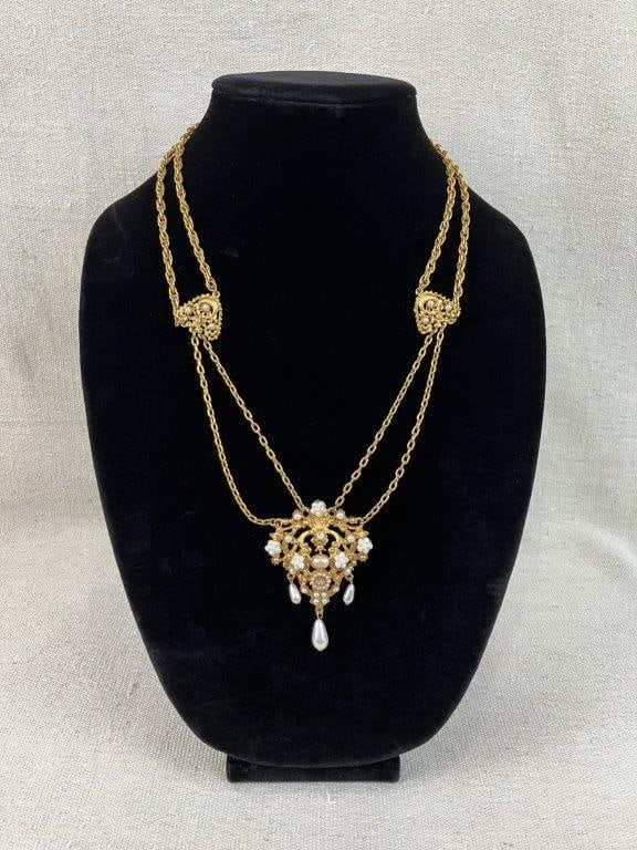 Florenza Gold-tone Necklace with Faux Pearls: This stamped Florenza necklace features an intricate gold-tone filigree and open-work design with a double-strand link chain held by decorative filigree connector plaques. The centerpiece is adorned