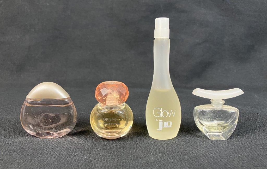 Four Vintage Perfume Bottles: Group of four vintage perfume bottles dating approximately from the late 1980s to the early 2000s, including one Glow by J.Lo perfume bottle and three petite examples of varying form. All retain