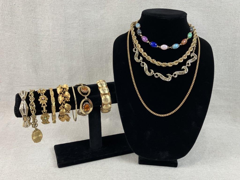 Gold Tone Costume Jewelry Assortment Including Napier and Hobe: Group of twelve pieces of vintage costume jewelry in gold tone, including a bracelet by Hobe with floral decorated panels on a mesh background, a unicorn charm bracelet with opening compartment, and