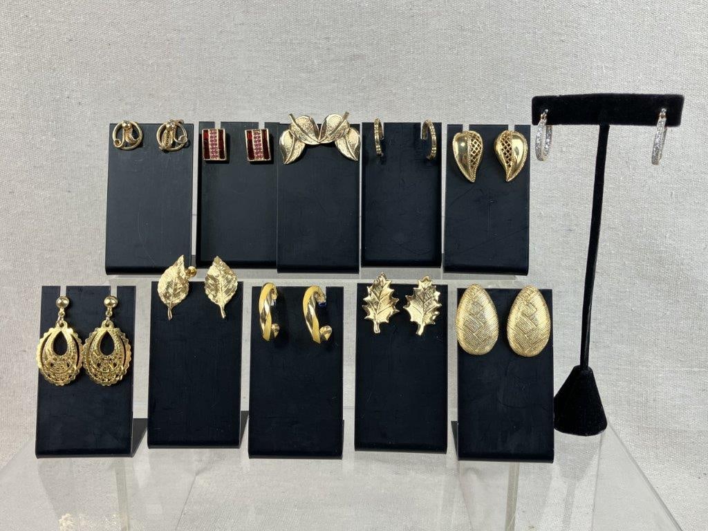 Gold Tone Costume Jewelry Earrings Assortment Including Napier: Group of twelve vintage costume jewelry earrings in gold tone, including a variety of forms such as leafy designs, reticulated examples, huggie hoops, dangle earrings, screw-back styles, and clip-on
