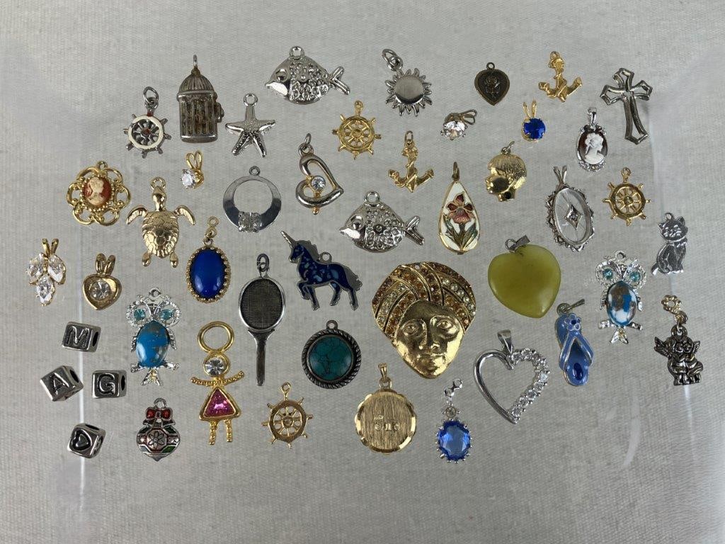 Pendant Costume Jewelry Assortment Including Avon: Group of forty-five vintage costume jewelry pendants, including a La Mode gold tone monogram pendant, one Avon gold tone framed example set with a luminous blue stone, and a wide variety of