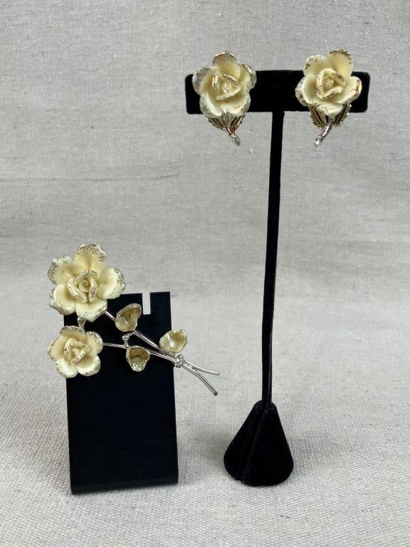Coro Floral Brooch and Earrings: This silver-tone set of Coro jewelry features a floral stem brooch with white enamel petals accented by gold-tone details and a matching pair of earrings. The brooch measures approximately 3 1/2 in.