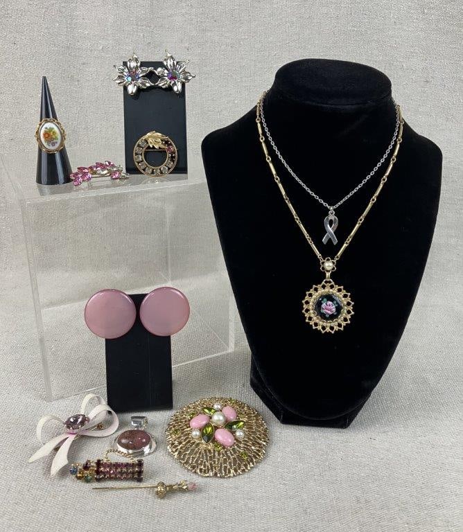 Assortment of Pink and Gold Tone Jewelry Including Sarah Coventry and Avon: Group of twelve pieces of vintage costume jewelry in pink tones and gold tone settings, including an Avon ring with an enamel floral motif and hinged compartment, and a large filigree brooch by Sarah