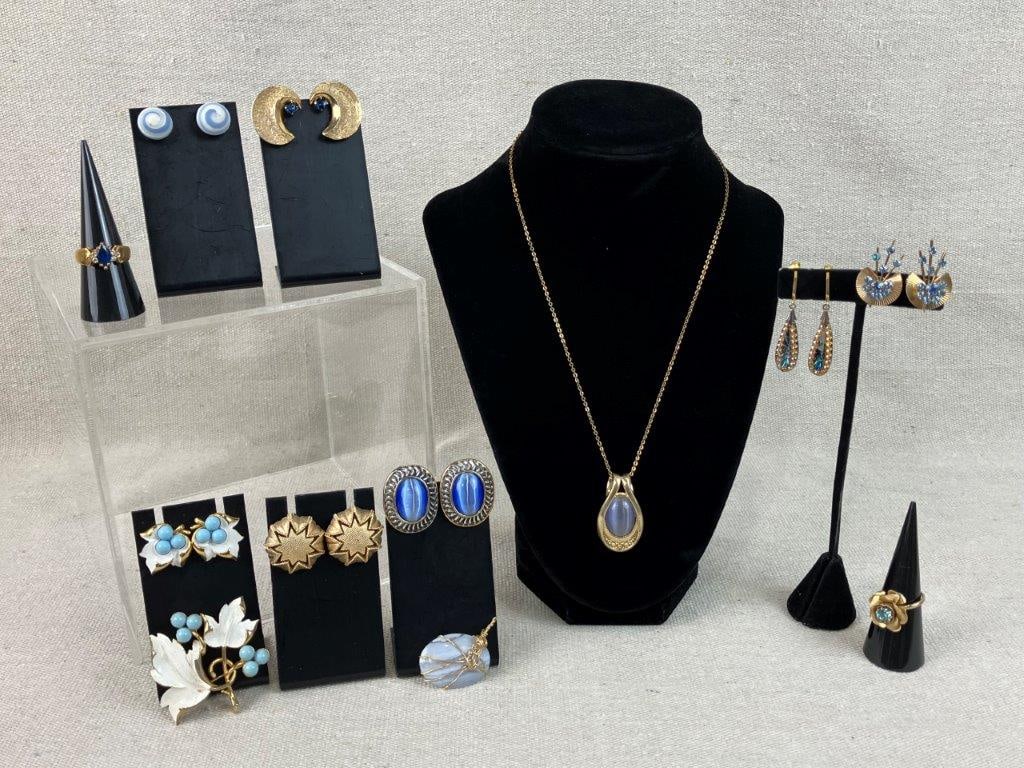 Blue and Gold-tone Jewelry Assortment Including Trifari and Sarah Coventry: A striking twelve-piece collection of vintage costume jewelry combining the enduring appeal of gold-tone settings with deep blue accents and high-end designer craftsmanship. The set is headlined by a