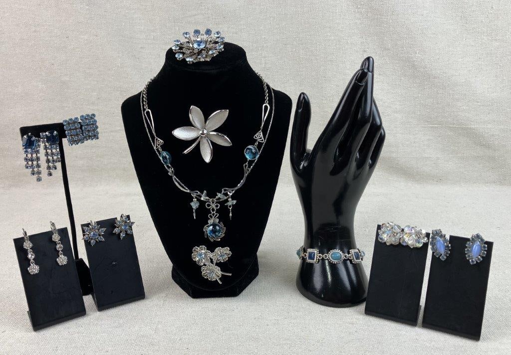 Collection of Blue Gemstone Jewelry: This collection of blue gemstone jewelry features a selection of silver-tone pieces accented by a spectrum of cool blue tones. The set includes a festive snowflake brooch and matching clip-on
