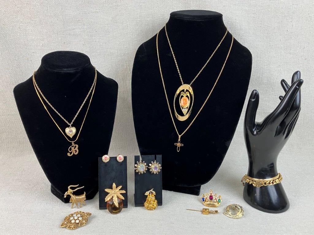 Assortment of Gold-Tone Jewelry: This gold-tone jewelry assortment features a whimsical variety of motifs, headlined by a Sarah Coventry pineapple brooch set with a faceted amber-colored glass stone. The collection also includes a un