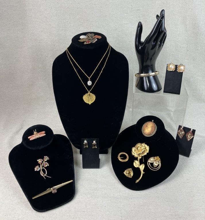 Assortment of Gold Tone Costume Jewelry Including Cameo Pendant: Group of fifteen pieces of vintage costume jewelry in gold tone, including two pendants, one a standout cameo depicting a woman in relief with floral adornment in her hair, one bangle bracelet, three 