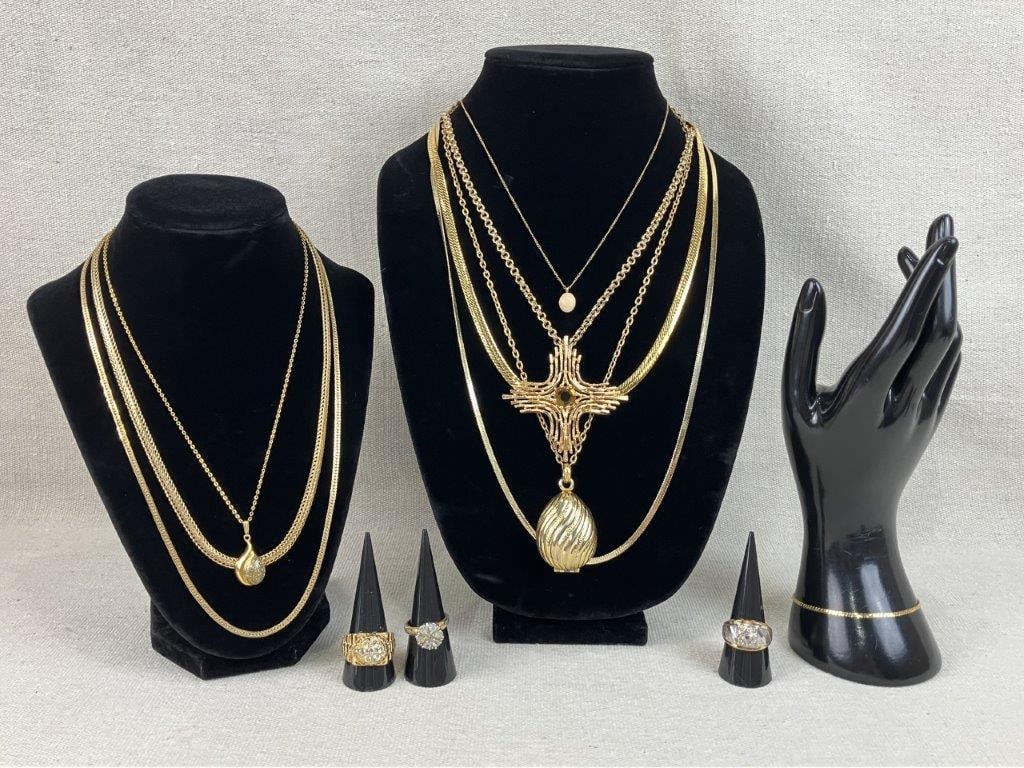 Assortment of Gold-tone Necklaces and Rings Including Avon and Sarah Coventry: This twelve-piece collection of gold-tone jewelry features notable vintage designs, including an Avon solid perfume necklace with an egg-shaped medallion perfume container featuring a linear design on