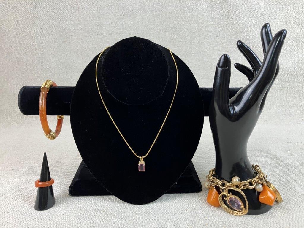 Assortment of Gold-tone Costume Jewelry Including Napier: This four-piece assortment of gold-tone costume jewelry features vibrant accents and classic vintage styling. The collection includes a gold-tone charm bracelet decorated with heart-shaped dangles con