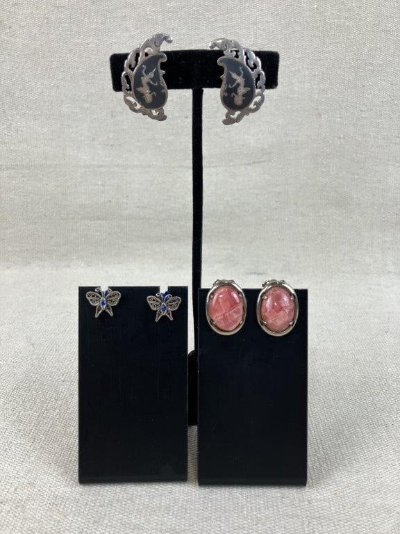 Assortment of Vintage Sterling Silver Earrings: This three-pair collection of vintage silver earrings showcases a variety of international styles and gemstone accents. The assortment features a pair of Siam Niello earrings depicting a Thai temple