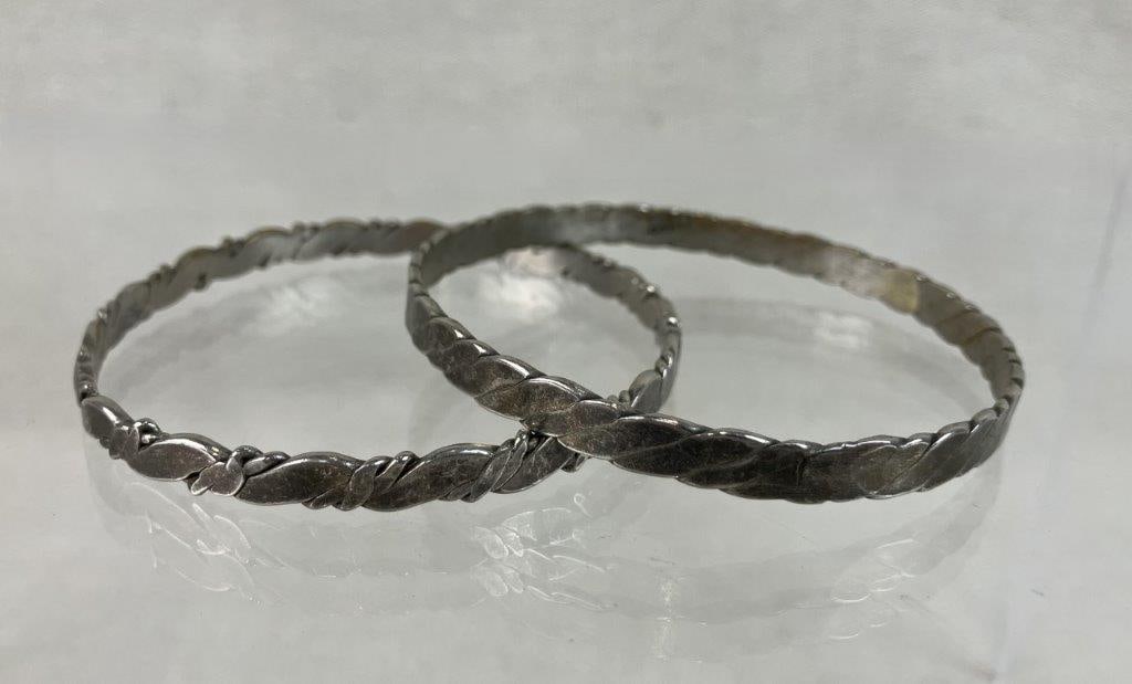 Laton Mexico Sterling Silver Bangle Bracelets: This pair of Laton Mexico bangle bracelets features a classic twisted rope design. Both pieces are stamped "Laton Mexico," signifying a construction of .925 sterling silver with brass accents. One