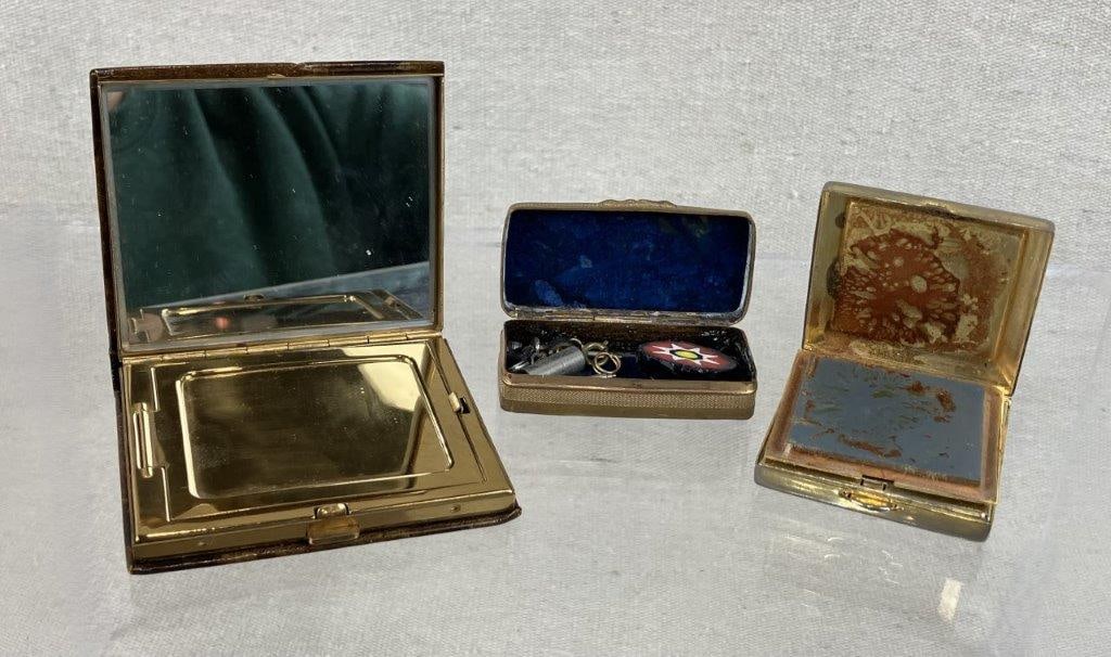 Lapis Lazuli Pill Box and Vintage Compact Assortment: This three-piece collection includes an Estee Lauder makeup compact adorned with a New York skyscraper scene featuring the Empire State Building, a classic leather-wrapped mirror compact, and a vibran