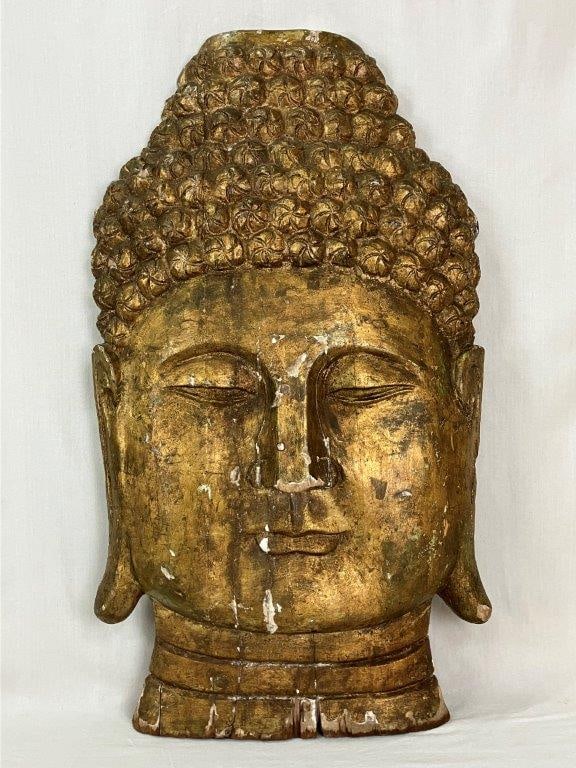 Huge Gilt Buddha Head Wall Sculpture: This large wall-mounted sculpture is crafted from carved wood and plaster, depicting a Buddha head with nicely carved features and stylized, tightly coiled curls and elongated earlobes. It features a