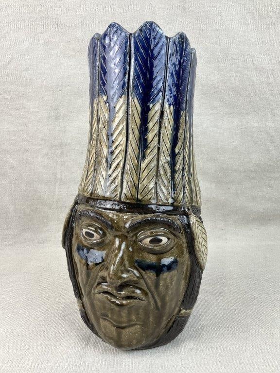 Clint Alderman Native American Face Jug: This exceptional folk art face jug by acclaimed regional potter Clint Alderman depicts a Native American figure with sharply defined features, an elaborate feathered headdress, and vibrant cobalt blue