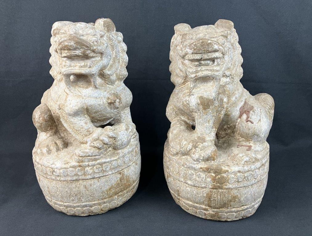 Pair of Ming Dynasty Carved Guardian Lions: Monumental pair of Ming Dynasty guardian lions, or "Foo Dogs," stands as a profound testament to the artistic traditions of the era, hand-carved from limestone with robust, muscular forms. The pair