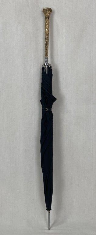 Fine Gold Plated Umbrella: A fine gold plated umbrella featuring an ornate gold plated handle with intricate detailing, paired with a modern working mechanism. The piece displays elegant decorative appeal suitable for both