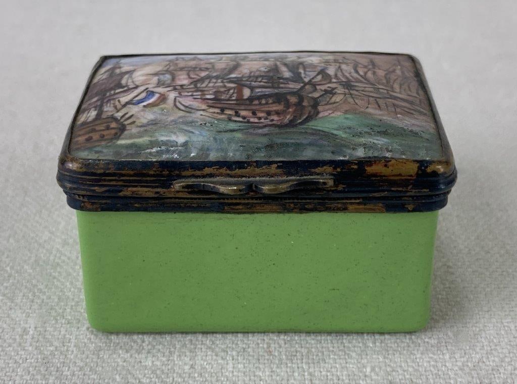 Antique French Enamel Snuff Box: This antique French snuff box features a hand-painted porcelain lid depicting a classic maritime setting with sailing ships, secured within a brass mount. The lid is paired with a vibrant, light