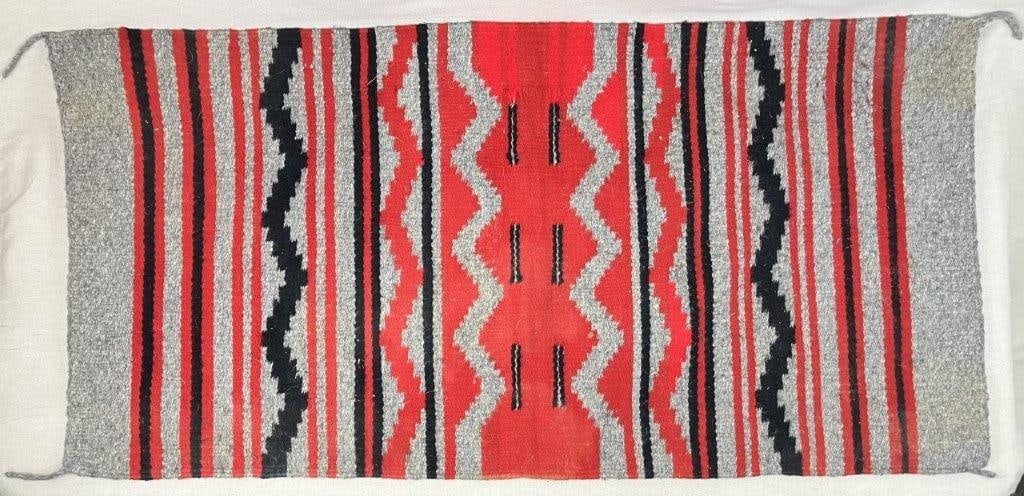 20th Century Navajo Rug: A 20th century hand-woven Navajo rug of native wools featuring a bold central field composed of stacked serrated concentric geometric lozenges and lightning motifs. It is finished with four intact