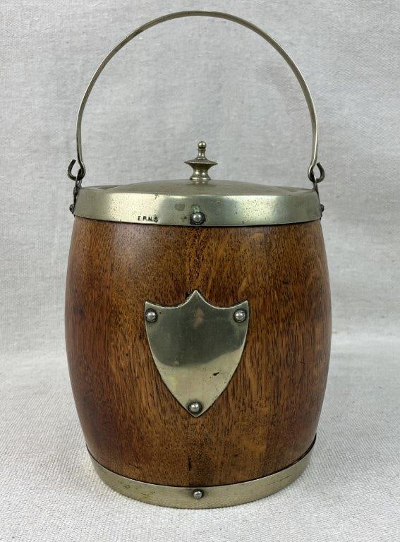 Oak and Silver Plate Biscuit Barrel: This handsome biscuit barrel features a beautifully grained oak wood body elegantly paired with a silverplate top and matching hardware composed of Electroplated Nickel Silver (E.P.N.S.). Seamlessly