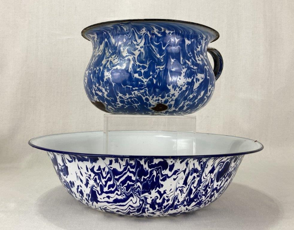 Blue Swirl Graniteware Chamber Pot and Bowl: A graniteware chamber pot and bowl with a blue and white swirl design. The chamber pot has an applied handle. The bowl has a darker cobalt blue swirl design. Both items have flared rims and display a