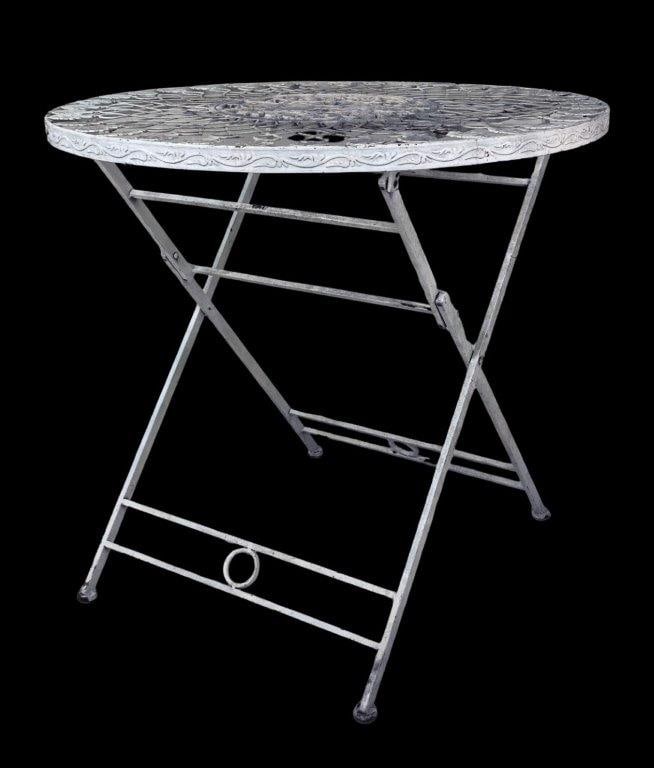 Cast Iron Bistro Table: This white-painted cast iron bistro table features a round top with a detailed, openwork radial design and a central ornate medallion. The construction includes interconnected loop structures, decorat