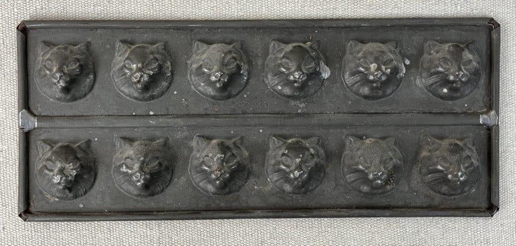 Antique Cat Candy Mold: This charming confectionery mold features multiple small cat impressions arranged across a single metal pan. Ideal for holiday treat-making or as an eye-catching display piece for a rustic or farmhous