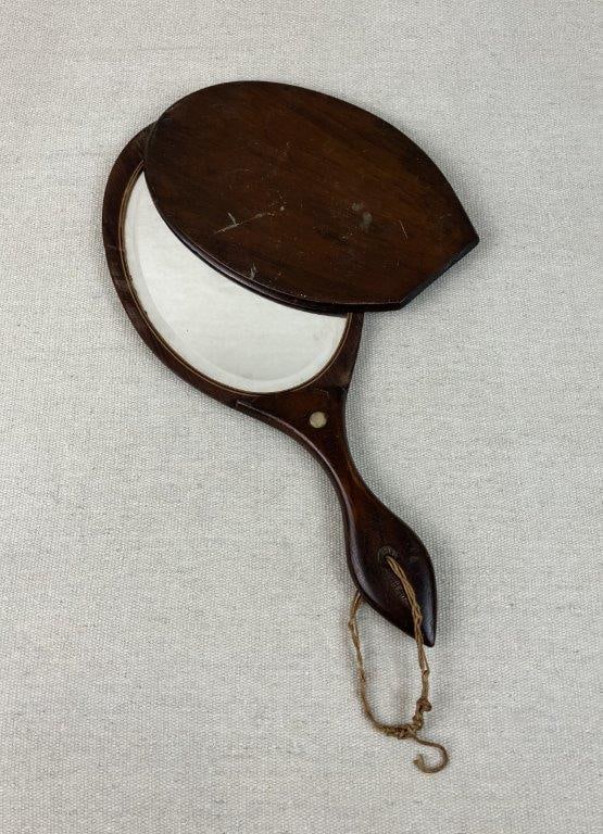 Civil War Era Mahogany Hand Mirror: This fascinating Civil War era traveling mirror features rich mahogany wood tones and a distinctive circular mother of pearl inlay set beautifully into the handle. Adding to its historical intrigue,