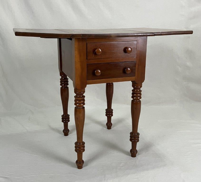 Mahogany Two Drawer Drop-Leaf Stand: A handsome mahogany two-drawer stand with drop leaves, raised on finely turned legs. The piece exhibits elegant proportions and fine craftsmanship, with the leaves providing versatile extension for